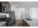 Modern kitchen with stainless steel appliances, granite countertops, and wood-look flooring at 24594 W St Catherine Ave, Buckeye, AZ 85326