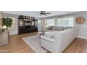 Cozy living room with a large sectional, wood floors, ceiling fan and multiple windows providing natural light at 2920 E Shady Spring Trl, Phoenix, AZ 85024