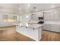 Modern kitchen with gray cabinets, island, and stainless steel appliances at 19031 W Palo Verde Dr, Litchfield Park, AZ 85340