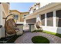 Relaxing patio with two hanging chairs and a brick walkway at 3799 S Skyline Dr, Gilbert, AZ 85297
