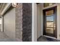 Stylish front door with glass panel, complemented by a sleek stone accent wall at 4353 N 203Rd Ave, Buckeye, AZ 85396
