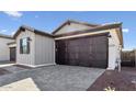 Charming home featuring a two-car garage and gray brick driveway at 20311 W Montecito Ave, Buckeye, AZ 85396