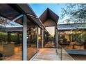 Modern home exterior with glass walls and walkway at 9556 E Celestial Dr, Scottsdale, AZ 85262