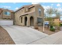 Two-story house with a tan stucco exterior, a three-car garage, and a landscaped front yard at 7351 W Palo Brea Ln, Peoria, AZ 85383