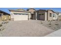 Modern home with light-colored brick exterior, two-car garage, and a paved driveway at 19020 W Ocotillo Rd, Waddell, AZ 85355