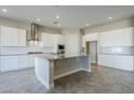 Spacious kitchen with white cabinets, granite island, and stainless steel appliances at 19020 W Ocotillo Rd, Waddell, AZ 85355