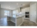 Modern kitchen with granite countertops, white cabinets, and a large island at 19020 W Ocotillo Rd, Waddell, AZ 85355