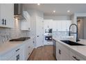 Modern kitchen with white cabinets, quartz countertops, and stainless steel appliances at 19014 W Ocotillo Rd, Waddell, AZ 85355