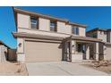 Two-story house with tan exterior, two-car garage, and desert landscaping at 18428 W Poston Dr, Surprise, AZ 85387