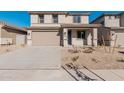 Two-story house with a tan exterior, two-car garage, and desert landscaping at 18428 W Poston Dr, Surprise, AZ 85387