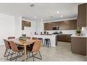 Open dining area and kitchen includes stainless steel appliances and ample counter space at 36378 W San Alvarez Ave, Maricopa, AZ 85138