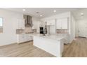 Bright kitchen with a large island, white cabinets, stainless steel appliances, and modern finishes at 11934 W Parkway Ln, Avondale, AZ 85323