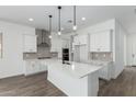 Bright kitchen boasts a center island with pendant lights, stainless steel appliances, and ample counter space at 11950 W Parkway Ln, Avondale, AZ 85323