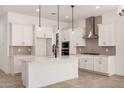 Modern kitchen with white cabinets, stainless steel appliances, a center island, and stylish pendant lighting at 12007 W Parkway Ln, Avondale, AZ 85323