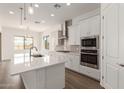 Kitchen with a large island, stainless steel appliances, and white cabinets offering a modern aesthetic at 12012 W Parkway Ln, Avondale, AZ 85323