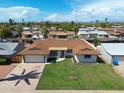 An aerial view of a well-maintained home with lush lawn, a large driveway and mature trees at 2236 E Blanche Dr, Phoenix, AZ 85022