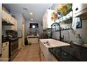 Well-lit kitchen featuring tile floors, granite countertops, and modern stainless steel appliances at 6313 W Onyx Ave, Glendale, AZ 85302