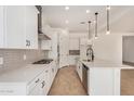 Well-lit kitchen featuring white cabinetry, stainless steel appliances, an island, and modern fixtures at 12015 W Parkway Ln, Avondale, AZ 85323