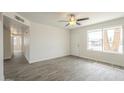 Bright living room with wood-look tile flooring, ceiling fan and a front door letting in natural light at 18009 N 15Th Dr, Phoenix, AZ 85023