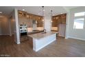 Modern kitchen boasts granite countertops, stainless steel appliances, and stylish pendant lighting over the island at 21369 W Hillcrest Blvd, Buckeye, AZ 85396