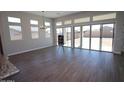 Bright living room featuring sleek floors, high windows, and multiple sliding glass doors to the backyard at 21369 W Hillcrest Blvd, Buckeye, AZ 85396