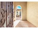 Inviting entryway with an arched opening and wrought iron gate for added security at 26747 N 127Th Dr, Peoria, AZ 85383