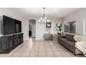 Spacious living room with tile floors, a modern couch, and a view into another room at 14244 W Indianola Ave, Goodyear, AZ 85395