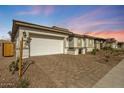 Exterior shot of a one-story home with a brick driveway and a two-car garage at 8746 W Denton Ln, Glendale, AZ 85305