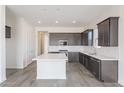 Modern kitchen with dark cabinetry, quartz countertops, and stainless steel appliances at 17993 W Long Lake Rd, Goodyear, AZ 85338