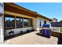 Outdoor patio with brick paving, grill, and windows reflecting backyard at 1531 W Plana Ave, Mesa, AZ 85202