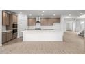 An open kitchen with a large white island, pendant lighting, stainless appliances, and a pantry at 2957 E Cherry Hill Dr, Gilbert, AZ 85298