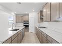 A modern kitchen features stainless appliances, quartz countertops, and ample wood cabinetry at 2957 E Cherry Hill Dr, Gilbert, AZ 85298