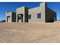 Contemporary home featuring a flat roof and simple lines, with a light stucco exterior set on a expansive, unfinished plot at 504 N 297Th Ln, Buckeye, AZ 85396