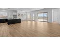 Bright, open-concept living area with wood-look tile flooring and an abundance of natural light, seamlessly connects indoor and outdoor spaces at 32535 N 135Th Dr, Peoria, AZ 85383