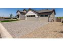 Exterior view showcasing a multi-car garage, mixed stone and siding facade, and manicured landscaping at 1606 E Minton St, Mesa, AZ 85203