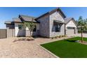 Side view of an elegant home featuring stone accents, well-kept landscaping, and a pristine lawn at 1606 E Minton St, Mesa, AZ 85203