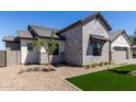 Exterior side view of a home featuring stone and siding, tasteful landscaping, and well-maintained turf at 1606 E Minton St, Mesa, AZ 85203