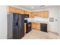 Functional kitchen featuring wood cabinets, black appliances, and durable tile flooring at 634 S Pasadena --, Mesa, AZ 85210