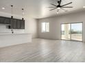 Spacious living room with gray ceramic tile flooring and sliding glass doors to back patio at 22205 W Ocupado Dr, Wittmann, AZ 85361