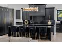 Stunning black kitchen with island seating, gold hardware, and modern lighting fixtures at 12651 S 71St St, Tempe, AZ 85287