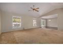 Spacious living room featuring vaulted ceilings, carpeting, and large windows at 25809 S Hollygreen Dr, Sun Lakes, AZ 85248