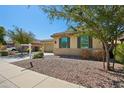 Charming home with desert landscaping and dark shutters on the windows at 19591 W Lincoln St, Buckeye, AZ 85326