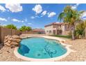 Inviting kidney-shaped pool with rock feature in backyard at 11543 E Quade Ave, Mesa, AZ 85212