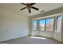 Bright bedroom with large window and ceiling fan at 19661 N Echo Rim Dr, Surprise, AZ 85387