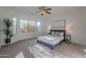 Relaxing bedroom with gray bed, large window, and neutral decor at 19661 N Echo Rim Dr, Surprise, AZ 85387