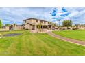 Expansive backyard with lush lawn, trampoline, playground, and mature trees at 5312 N Sierra Hermosa Ct, Litchfield Park, AZ 85340