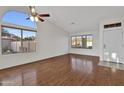 Bright living room featuring hardwood floors, a ceiling fan, and a large arched window at 20616 N Ventana W Dr, Peoria, AZ 85373