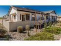 A rear view of the home featuring a covered patio, neutral color palette, and low-maintenance desert landscaping at 4505 S Mole --, Mesa, AZ 85212