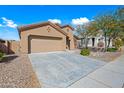 Tan house with a two-car garage and desert landscaping at 41432 N Bent Creek Way, Phoenix, AZ 85086