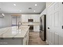 White kitchen cabinets, quartz countertops, and a stylish gold faucet at 41432 N Bent Creek Way, Phoenix, AZ 85086